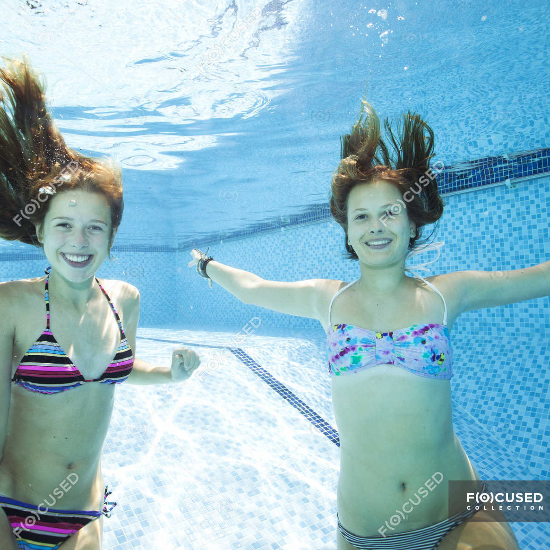 focused_164937736-stock-photo-two-teenage-girls-swimming-underwater