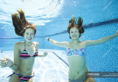 focused_164937736-stock-photo-two-teenage-girls-swimming-underwater